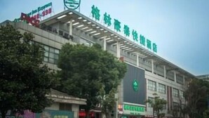 A large building with a green logo, multiple floors, and a covered entrance area. - Greentree Inn (Suzhou)