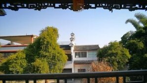 Un bâtiment traditionnel avec un toit en tuiles, entouré de verdure.