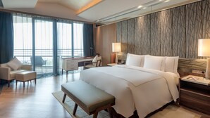 Een hotelkamer met een groot bed, een bureau, een stoel en een bank.