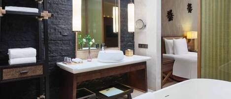 A modern bathroom with a large mirror, a white bathtub, and a wooden vanity.