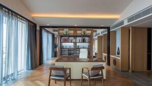 Een modern interieur met een centraal eiland, twee stoelen en een boekenkast.