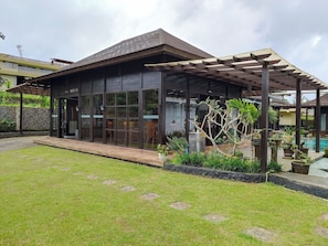 A modern house with a covered patio, a swimming pool, and a well-maintained lawn. - Merlyn Meadows Retreat (Munduk)