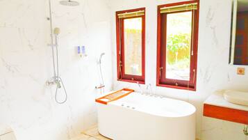 A modern bathroom with a freestanding bathtub, a showerhead, and two windows with red frames.