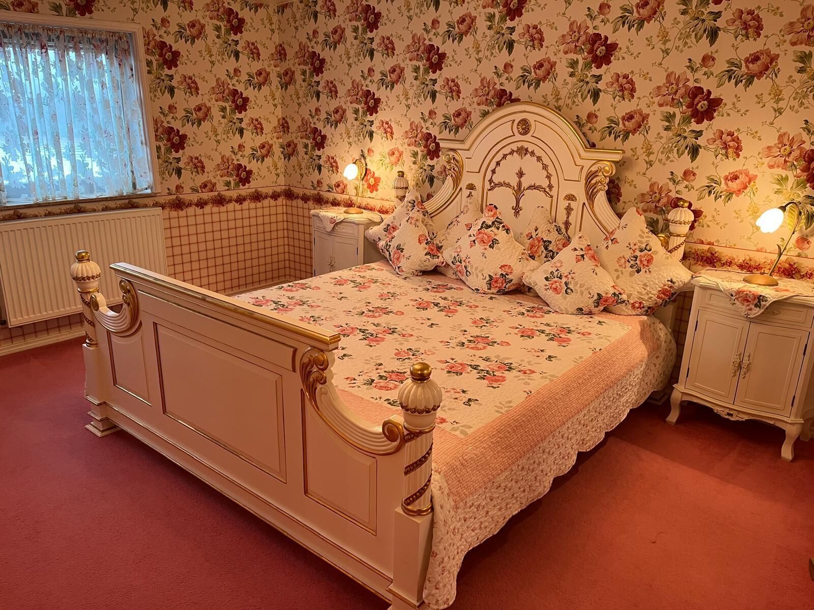 Kingsize-Bett mit Nachtschränkchen, Kleiderschrank und Schminktisch.