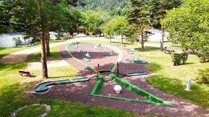 Un parcours de golf doté d’un green d’entraînement, de bunkers de sable et d’un pont.