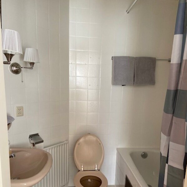 A bathroom with a toilet, sink, and bathtub.