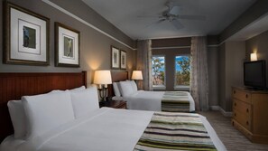 Habitación de hotel con dos camas, un televisor y cuadros en la pared.