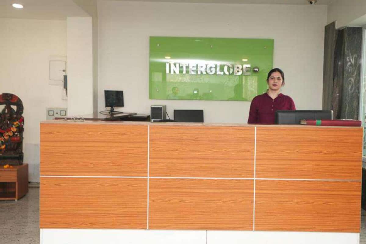 A reception desk with a green sign reading 'INTERGLOBE,' a computer, and a decorative item on the left.