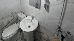Un baño con inodoro, lavabo y ducha.