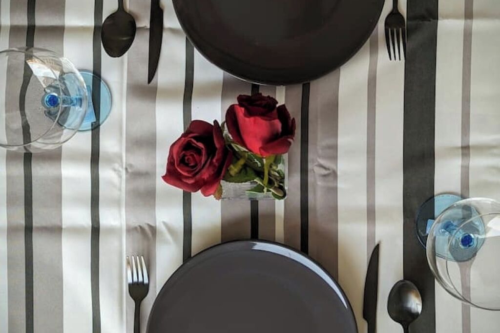 Een gedekte tafel met een bord, bestek en een glas water.