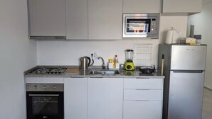 Een moderne keuken met een ingebouwde magnetron, gasfornuis, oven en koelkast.