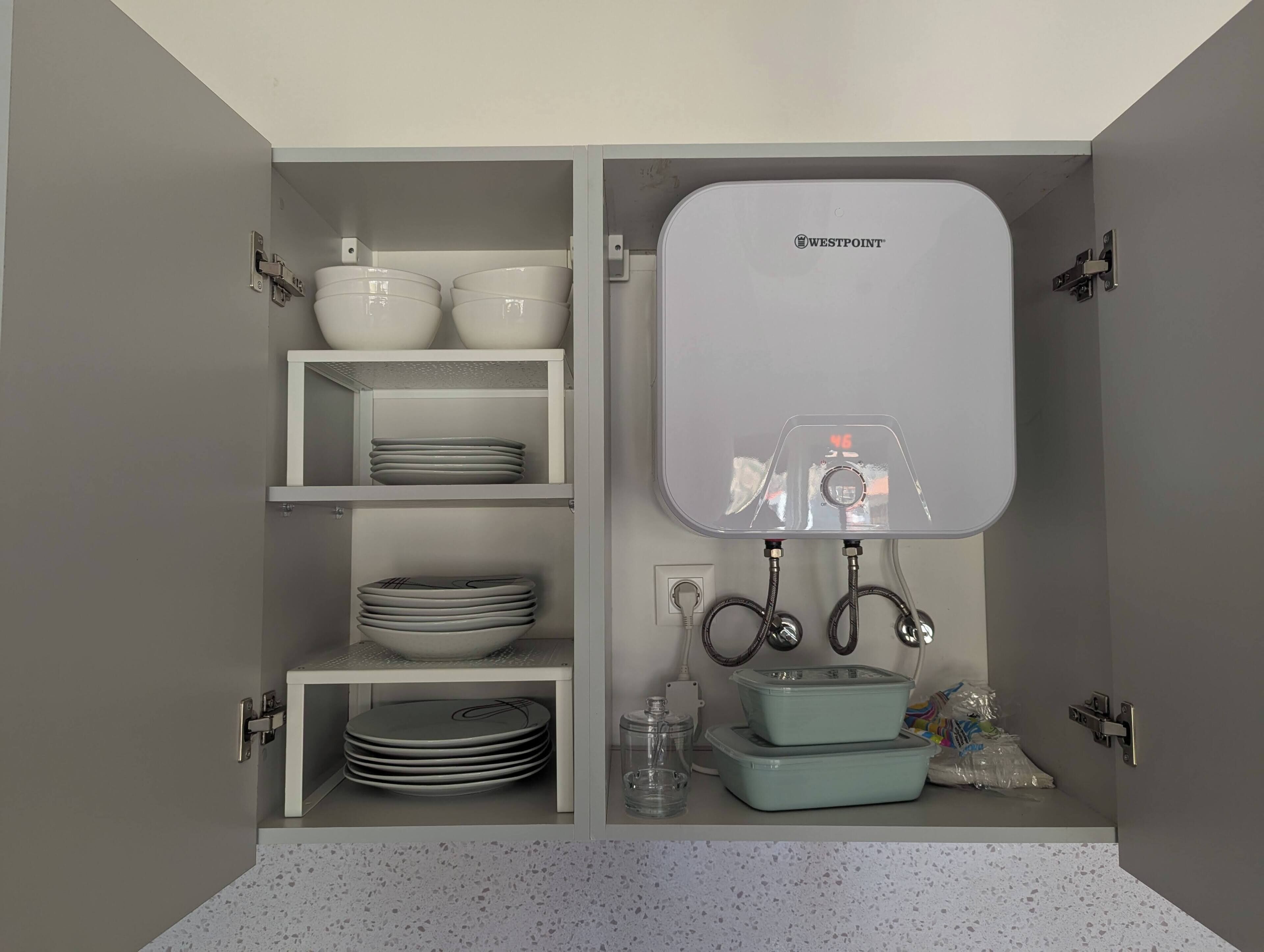 A kitchen with white cabinets, a Westpoint water dispenser, and various kitchen items.