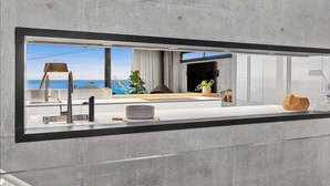 Una cocina moderna con un amplio ventanal, estufa integrada y vista al océano.