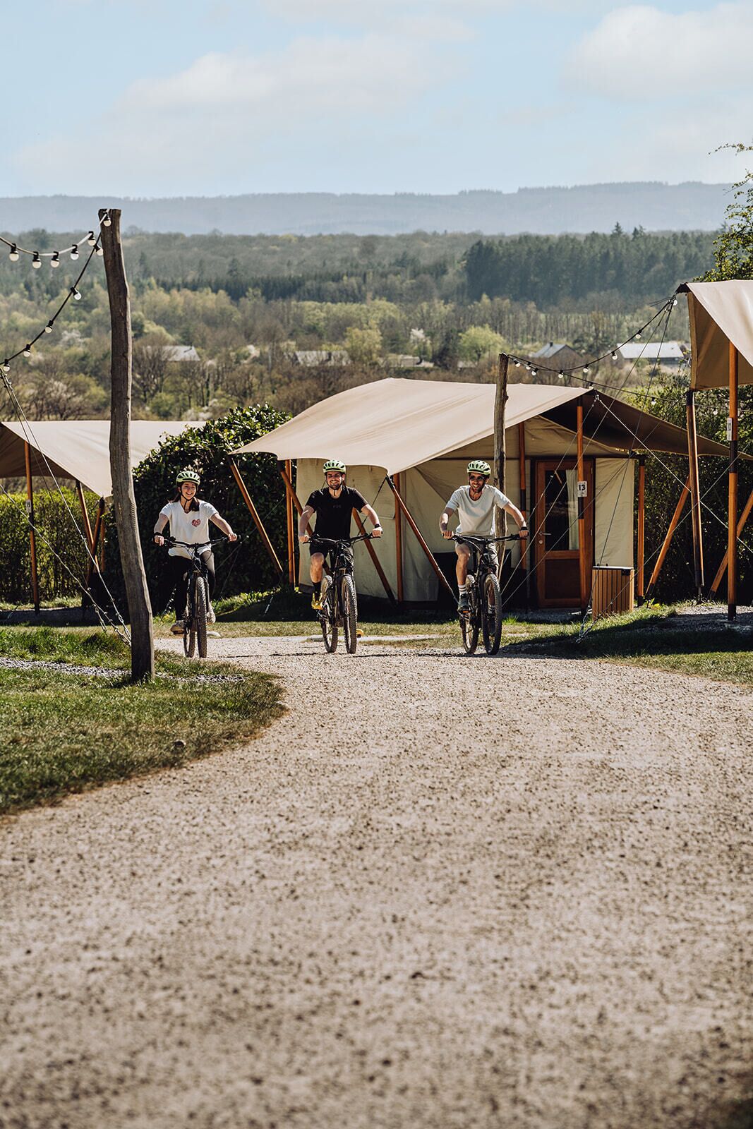 A gravel path with tents and bicycles.