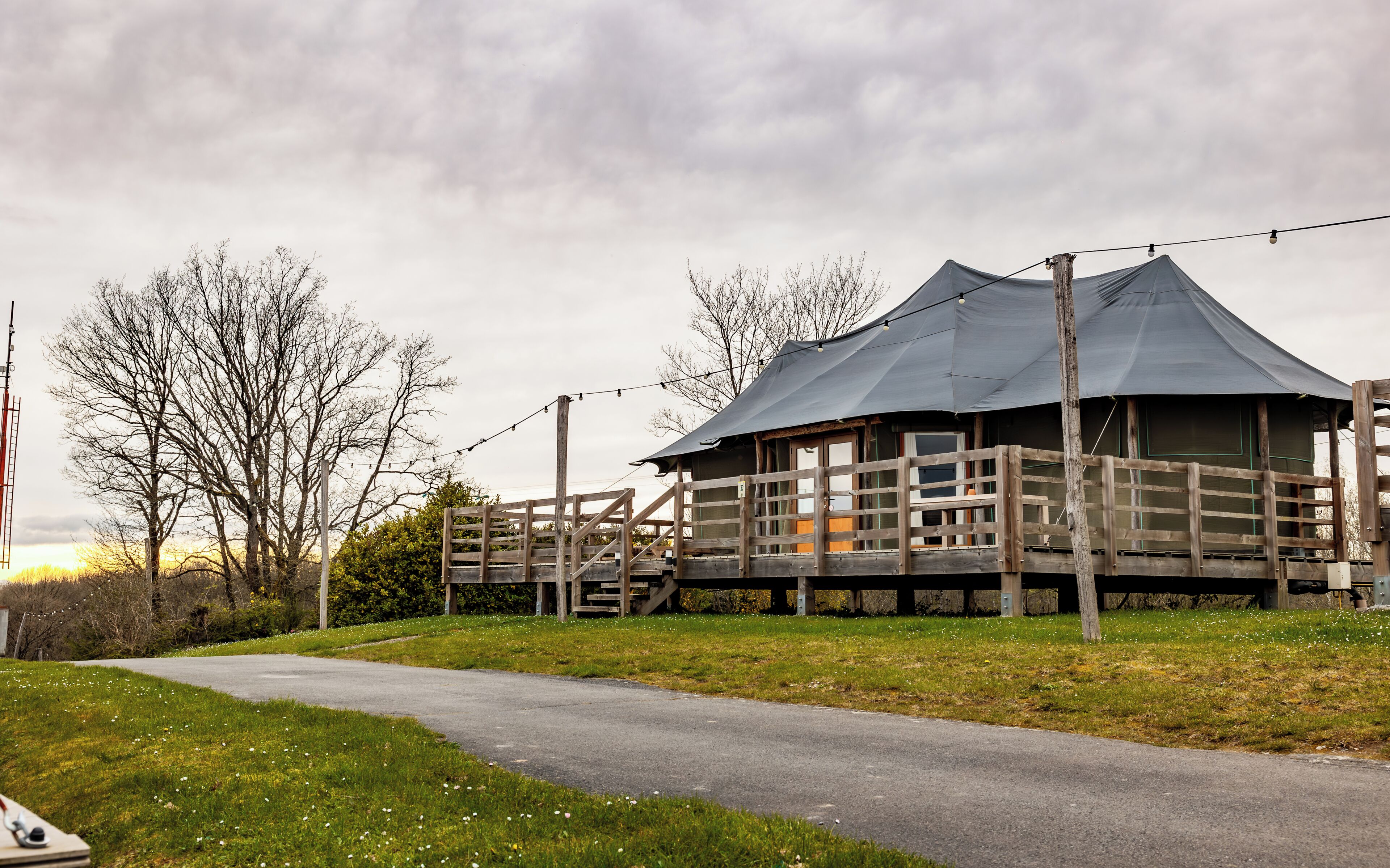 A wooden structure with a covered porch and a staircase leading to an upper level.