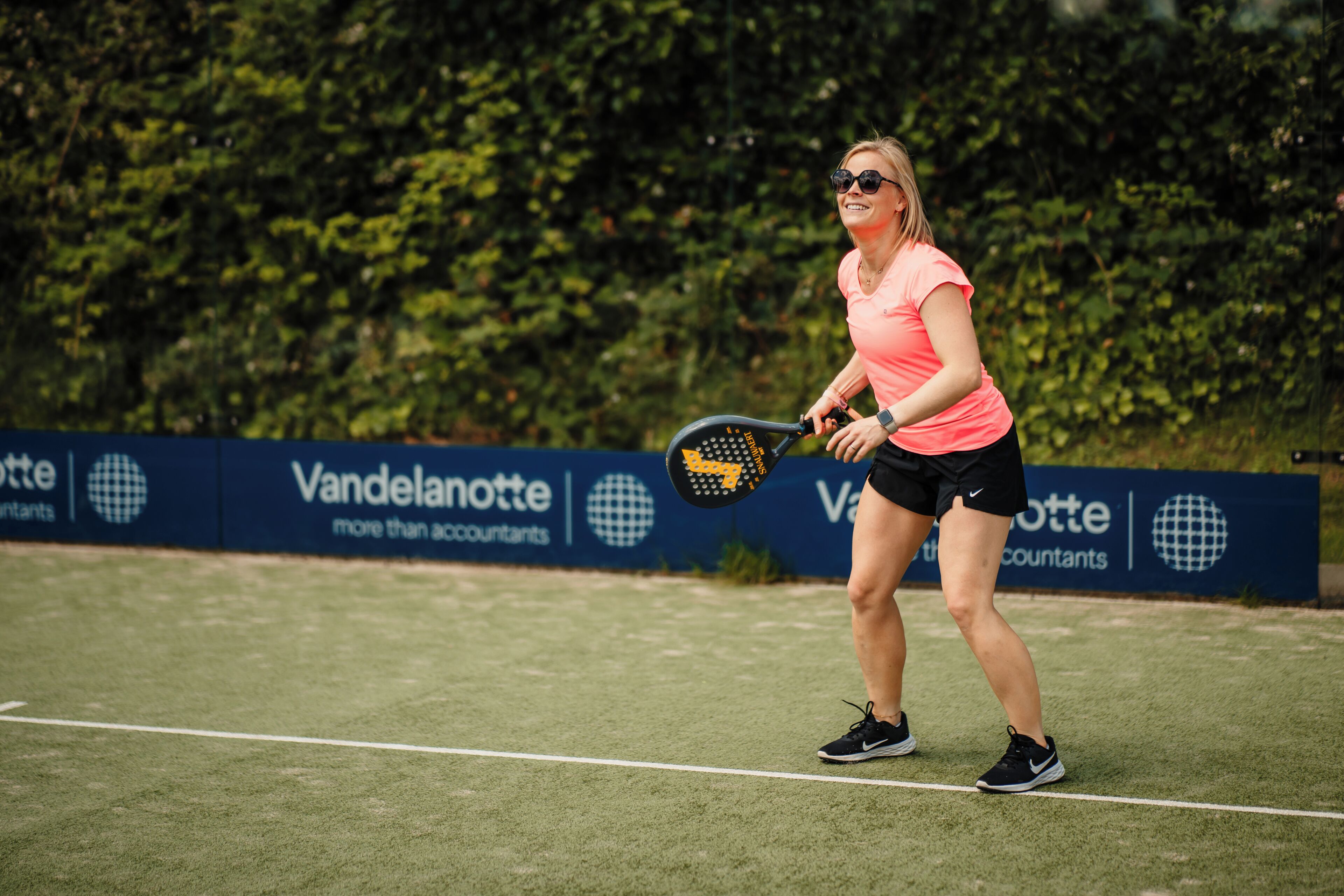 A tennis player on a court with a banner in the background.