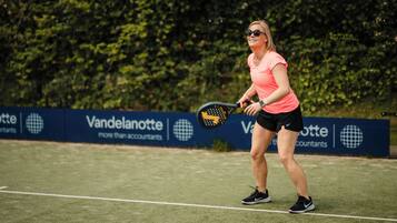A tennis player on a court with a banner in the background.