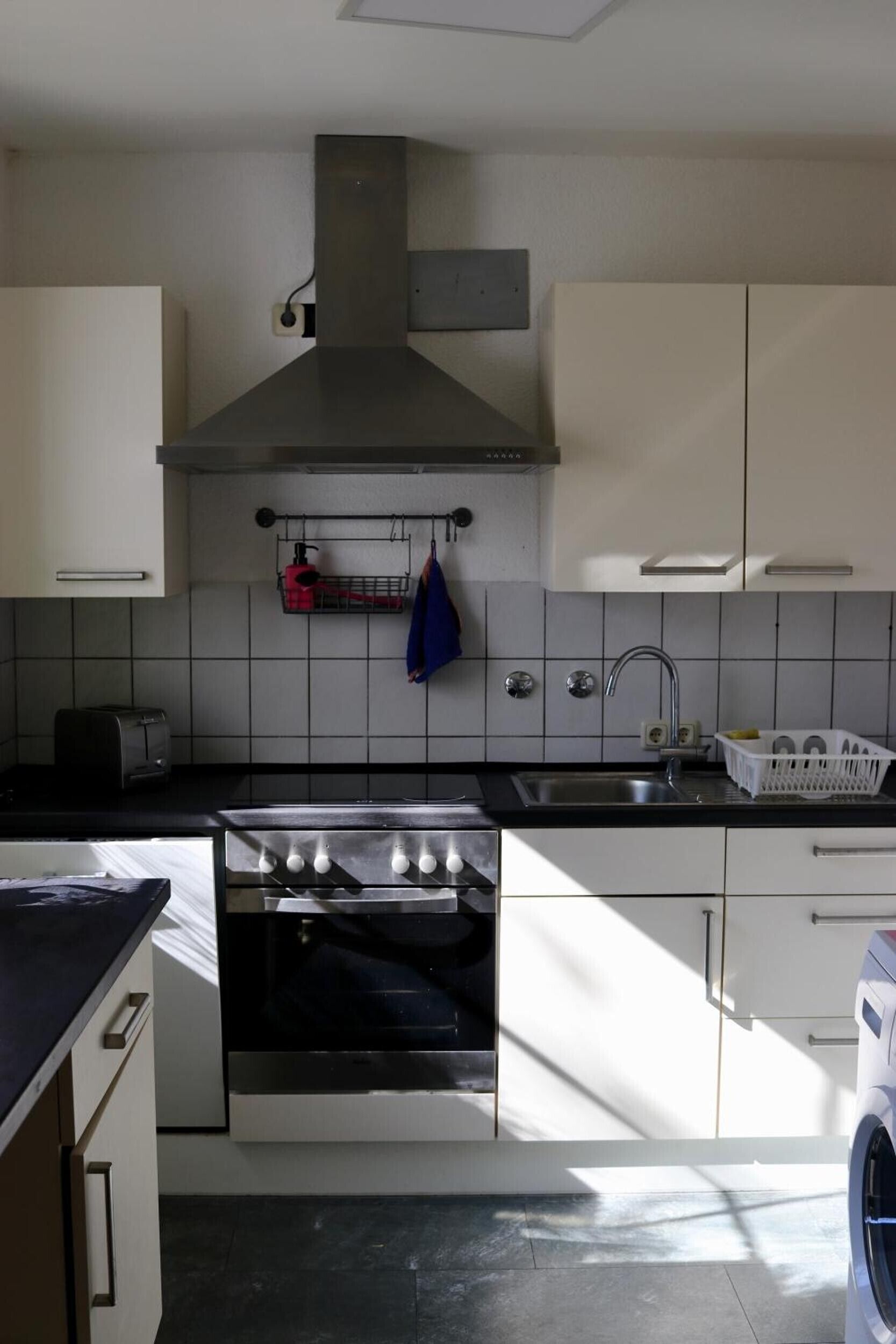 Une cuisine équipée d’une cuisinière, d’un four, d’un évier et de placards.