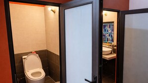 Ein Badezimmer mit Toilette, Waschbecken und Duschbereich.