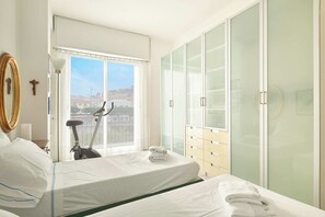 Une chambre d’hôtel avec un lit, un vélo d’exercice et une vue sur la ville.