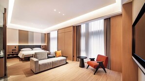 A modern hotel room with a bed, sofa, two chairs, a TV, and a large window with curtains. - MEHOOD LESTIE Hotel(Xi'an Xixian Wuyue Plaza Afanggong South Metro Station Store) (Xi'an)