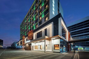 A modern hotel with multiple floors, large windows, and a well-lit entrance area. - MEHOOD LESTIE Hotel(Xi'an Xixian Wuyue Plaza Afanggong South Metro Station Store) (Xi'an)