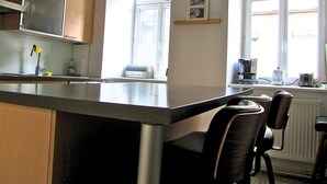 Eine Küche mit einer Kochinsel, einer Kaffeemaschine und einem Toaster auf der Fensterbank.