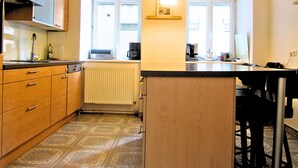 Eine kompakte Küche mit einer zentralen Kochinsel, einem Einbauofen und einer Heizkörper.