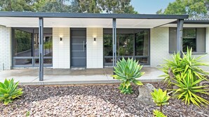 A modern house with a covered porch, large windows, and a garden with succulents. - Home among the Gum Trees - free wine (Tea Tree Gully)