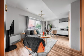 A modern living room with a sofa, coffee table, and TV. - MONDOMIO ODORI 901 (Sapporo)