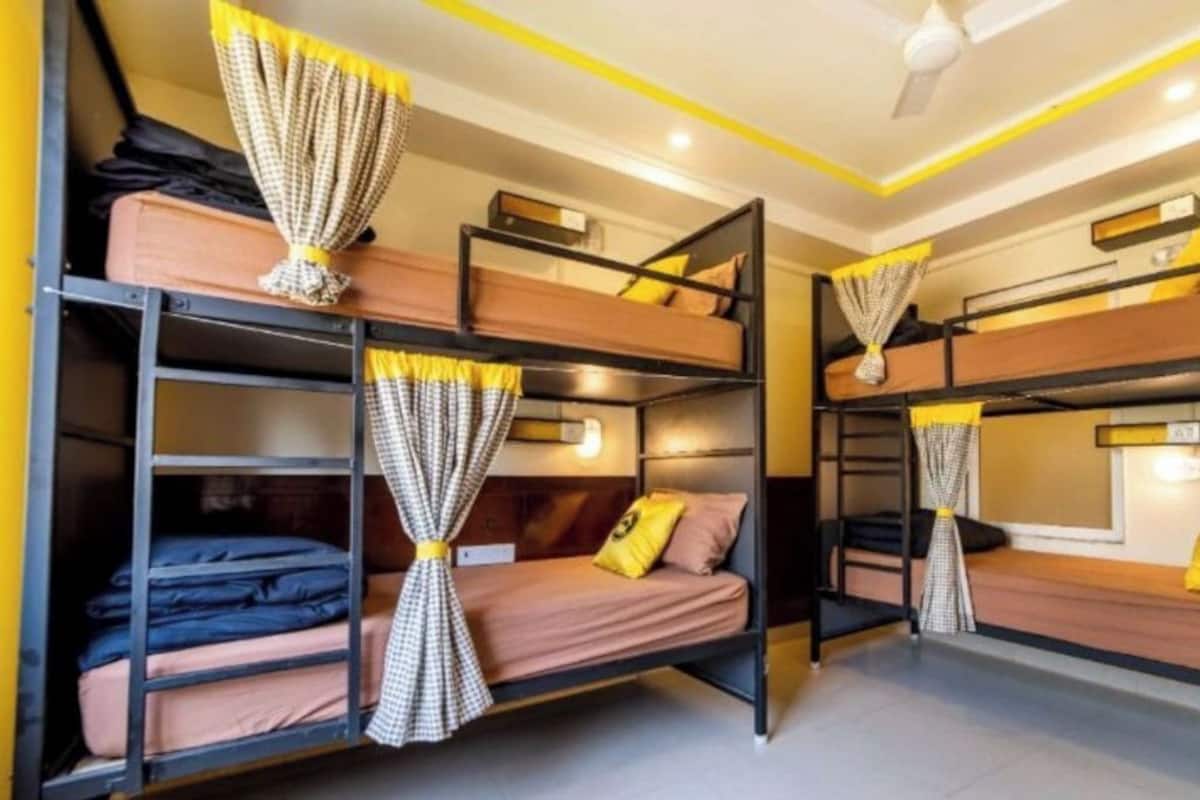 A bunk bed room with curtains, a ceiling fan, and a light fixture.
