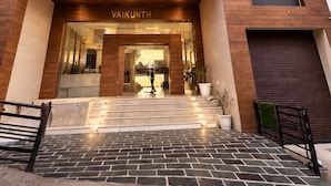 Un hotel de varios pisos con fachada moderna, una entrada destacada con puerta de vidrio y el nombre exhibido sobre la entrada.