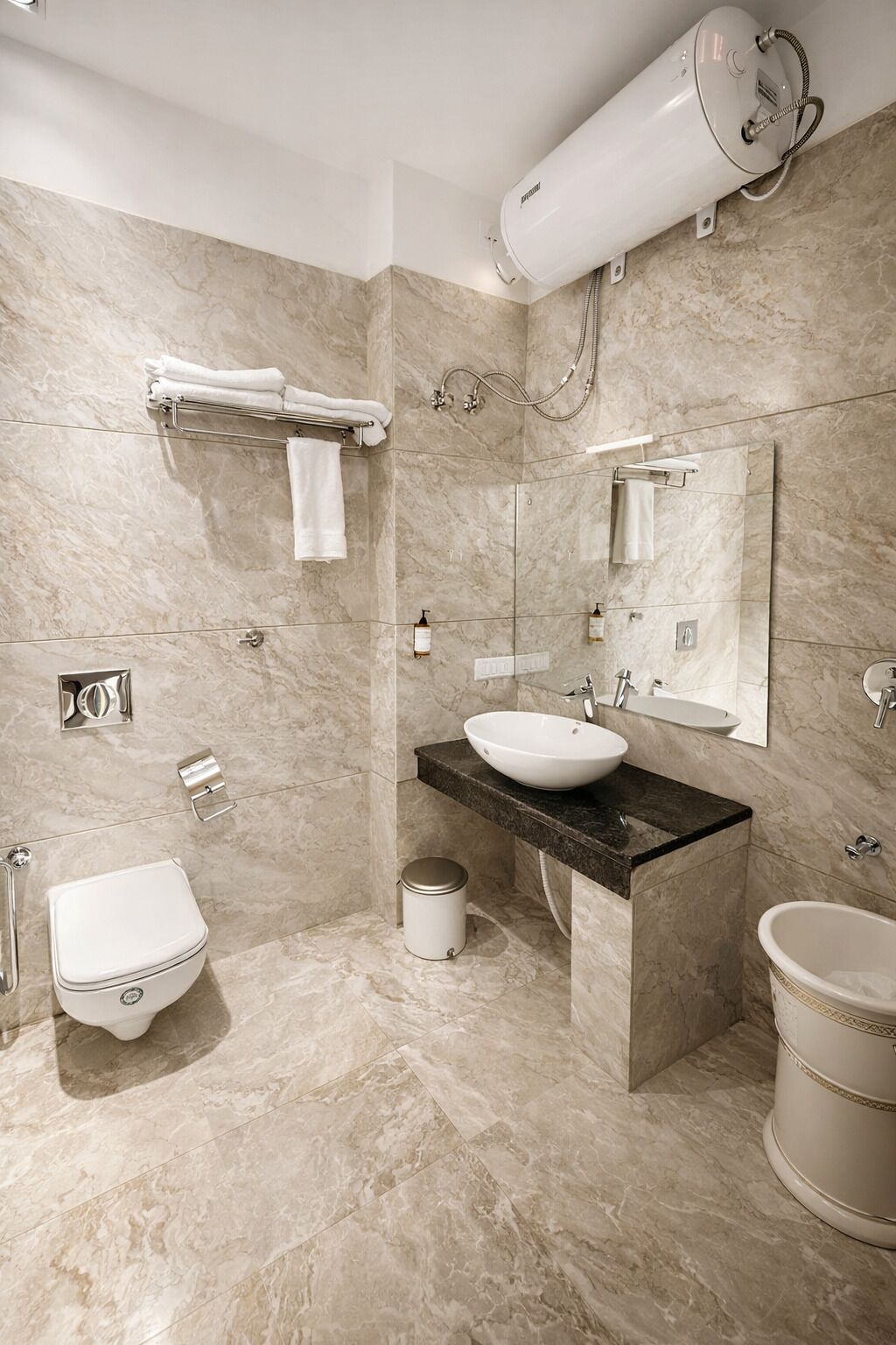 Une salle de bain moderne avec un sol en marbre, un lavabo blanc, des toilettes, un bidet et une baignoire.