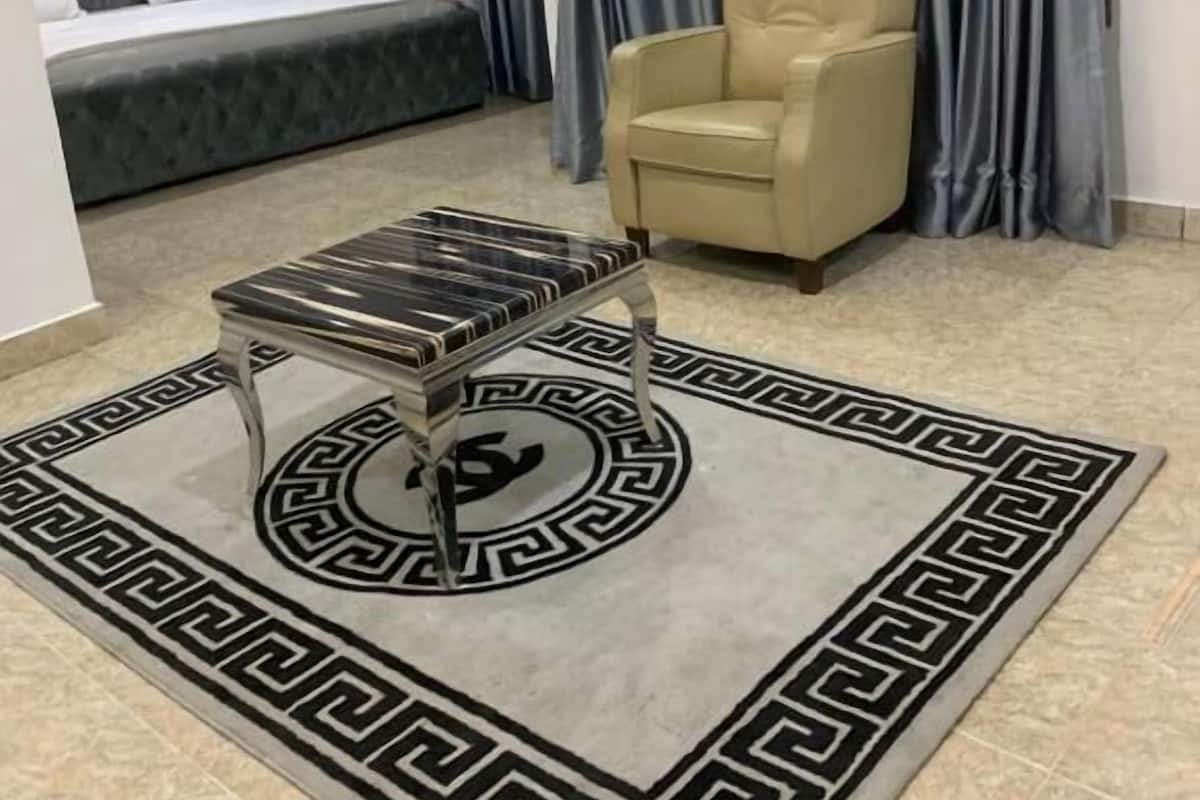 Un dormitorio con una cama, una silla y una mesa de centro.
