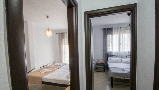 Un dormitorio con cama, mesita de noche y lámpara colgante.