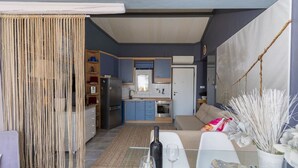 Un espacio habitable compacto con kitchenette, comedor y una pequeña zona de estar.
