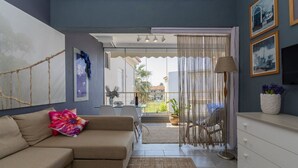 Una sala de estar moderna con un sofá, una mesa de comedor y un televisor.