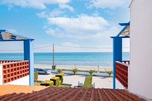 A view from a balcony overlooking a beach with a clear sky.