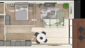 Distribución de una habitación de hotel con cama, sofá, mesa de comedor y pequeña cocina.