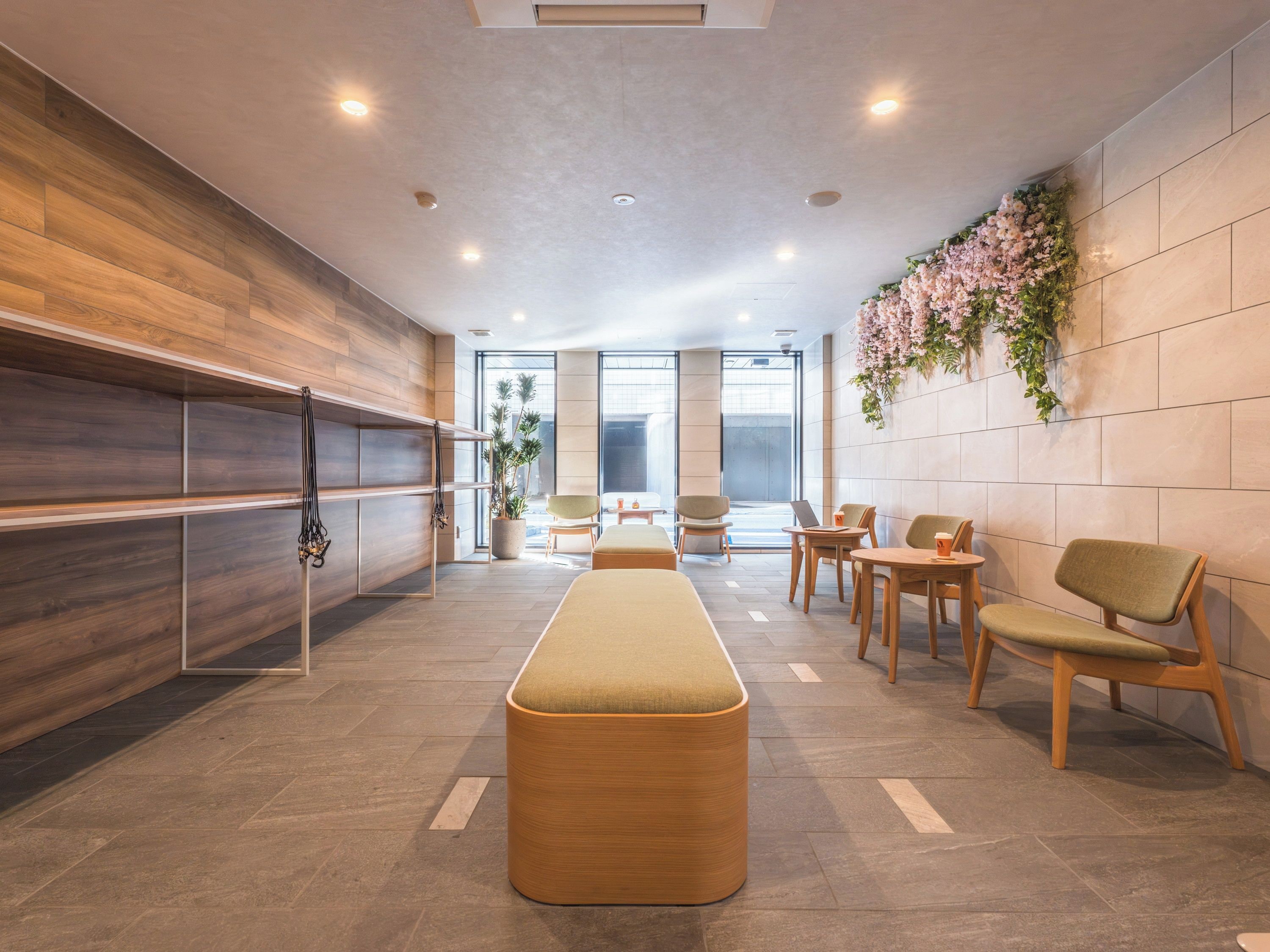 A modern interior with a reception desk, seating area, and a large window.