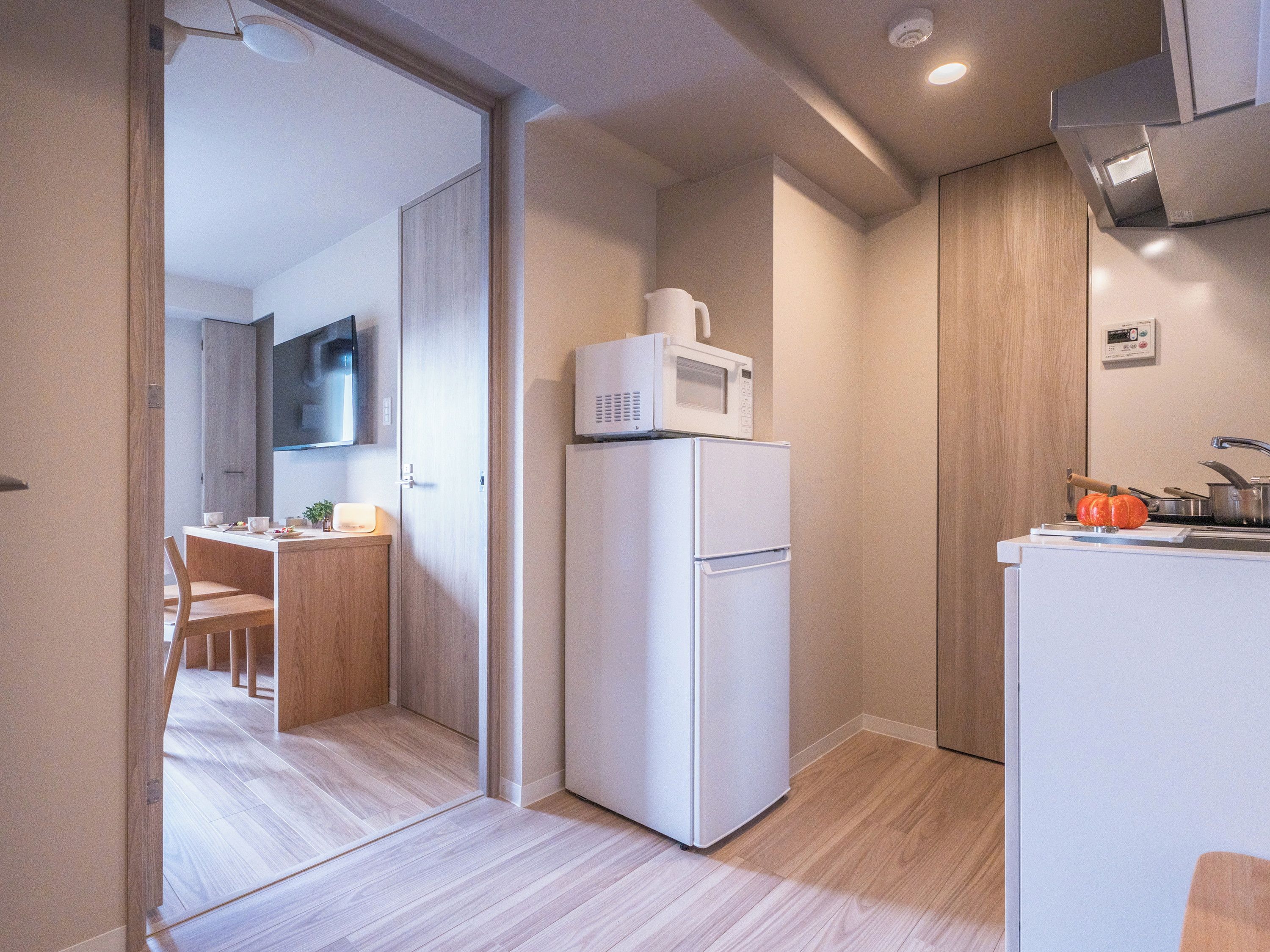 A compact kitchen with a microwave, refrigerator, and a small sink.