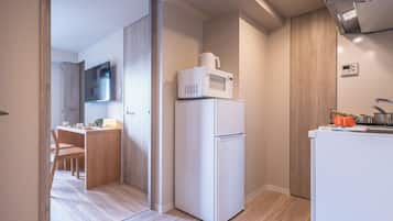 A compact kitchen with a microwave, refrigerator, and a small sink.