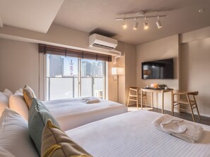 A hotel room with two beds, a desk, a chair, a TV, and a window with a city view. - ESLEAD HOTEL Namba East (Osaka)