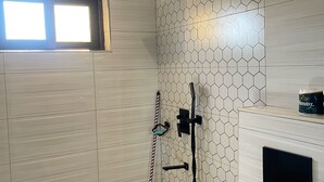 A modern bathroom with a shower, a toilet, and a window. - Charming 1-bedroom apartment with City View in lively Kampala (Kampala)