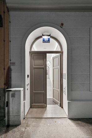 An arched entrance to a building with a door and a sign above it. - Nüll Residences Unit 38-Mainstation (Vienna)