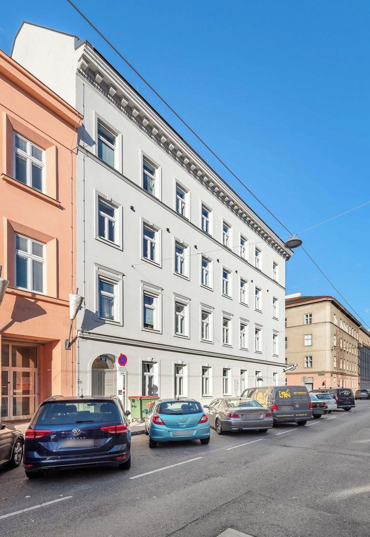 A multi-story building with a classic architectural style, featuring a row of windows and a flat roof.