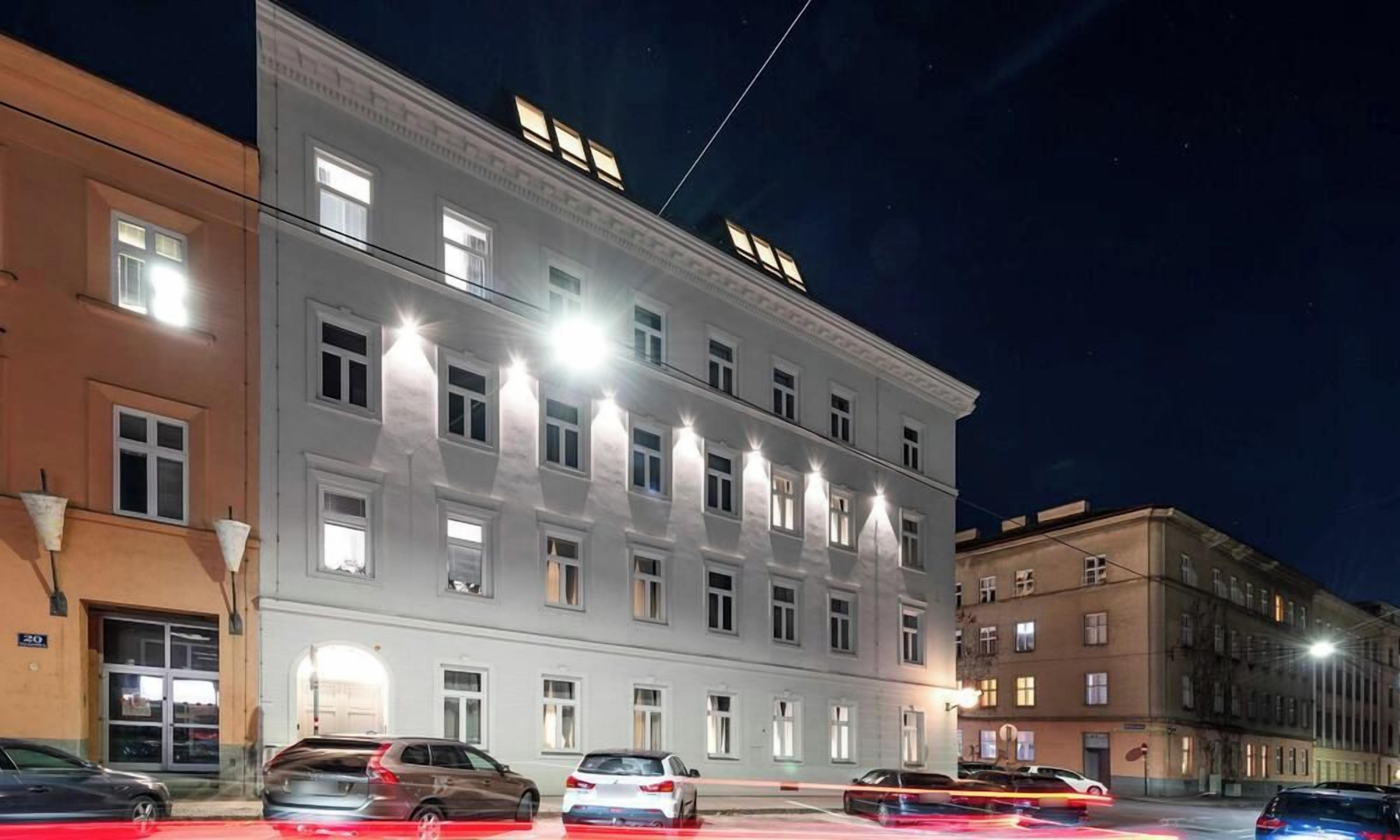 A multi-story building with illuminated windows and a flat facade.