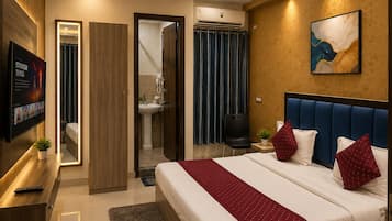 Habitación de hotel moderna con una cama grande, televisión, escritorio y baño visible a través de una puerta abierta.