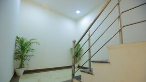 Una escalera con barandillas de metal y una planta en maceta a la izquierda.