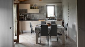 Cozinha moderna com mesa de jantar, cadeiras e janela.